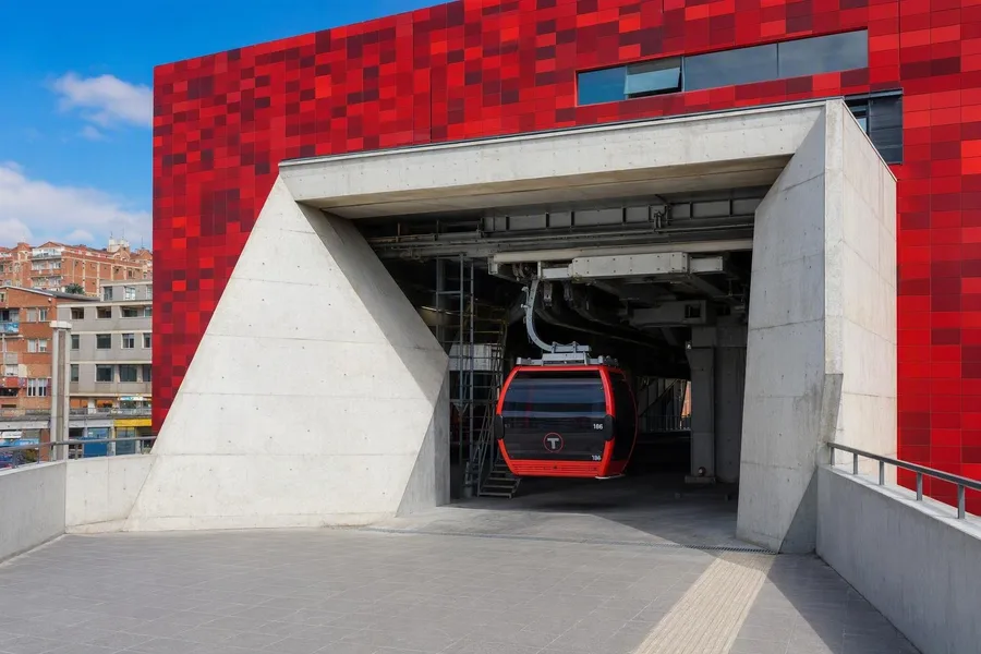 Een cabine van de Rode Lijn rijdt Jach’a Qhathu binnen onder het gepixelde rode volume in El Alto.