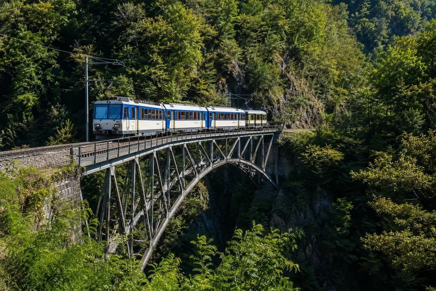 Een Centovalli-trein kruist de stalen Isorno-brug bij Intragna in de Zwitserse Centovalli.