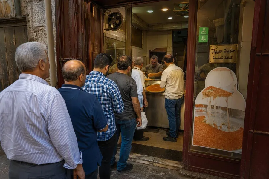 Klanten wachten bij Habibah Sweets aan de Al-Azharstraat om kunafa af te halen.