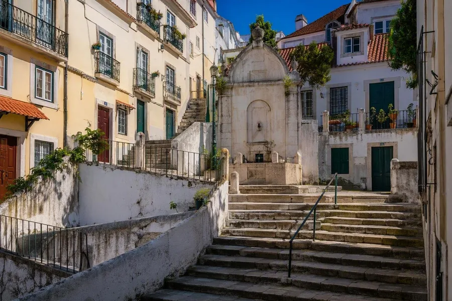 Een fontein van lioz-kalksteen staat boven trappen op Largo de São Miguel in Alfama.