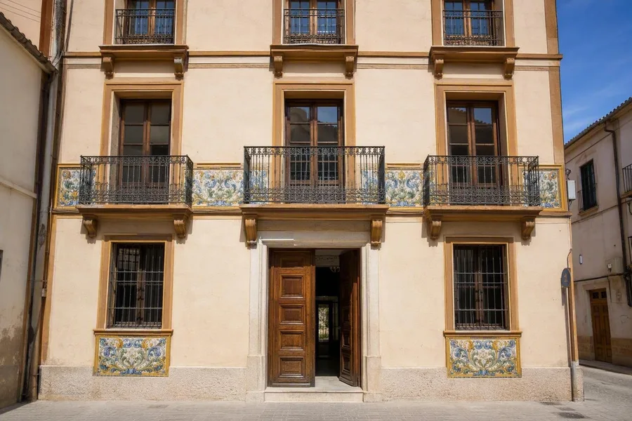 Achttiende-eeuwse veelkleurige tegels zitten onder de vensters van Casa Ferraro aan Carrer del Sagrari in Manises.