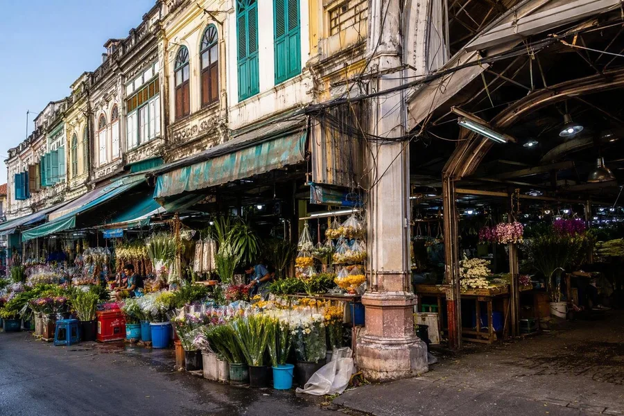 Bloemenwinkels, overdekte markten en oude shophouses liggen langs Chak Phet Road in Pak Khlong Talat.
