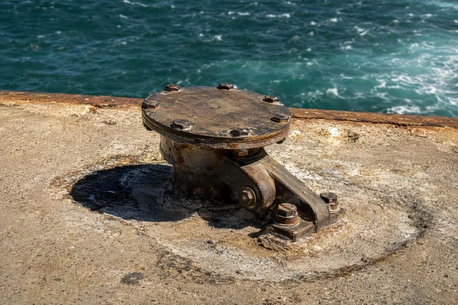 Een metalen bunkeraansluiting blijft vastgebout aan de betonnen steiger in Robert Harbour.