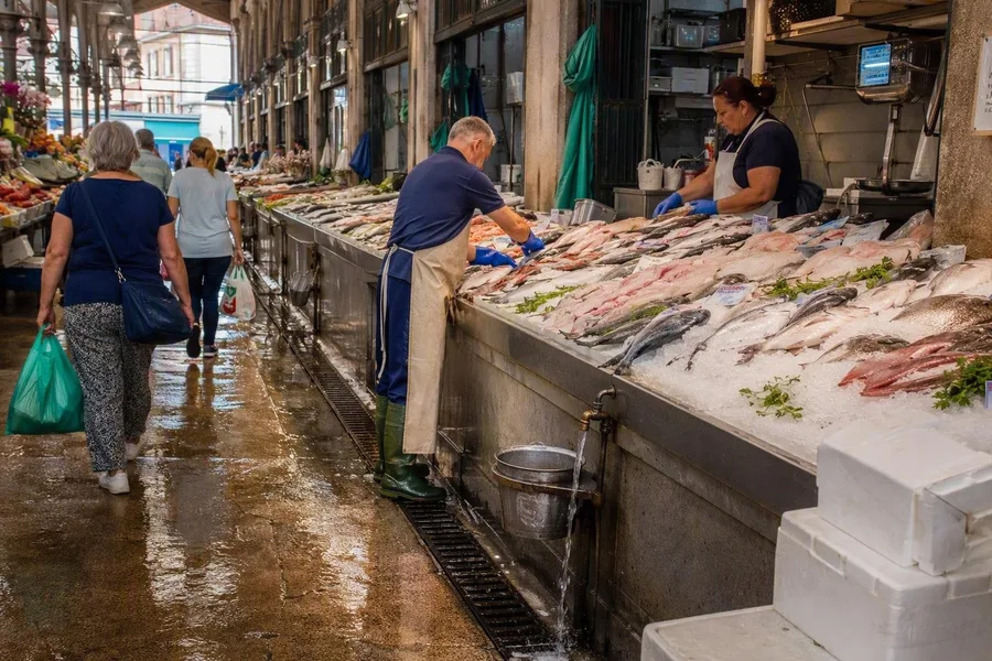 Verkopers werken naast vis op ijs in Mercado do Bolhão in Porto.