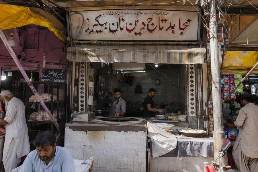 Mujahid Taj Din Naan Bakers ligt tussen dicht op elkaar staande winkels aan de hoofdstraat van Mozang Bazaar.