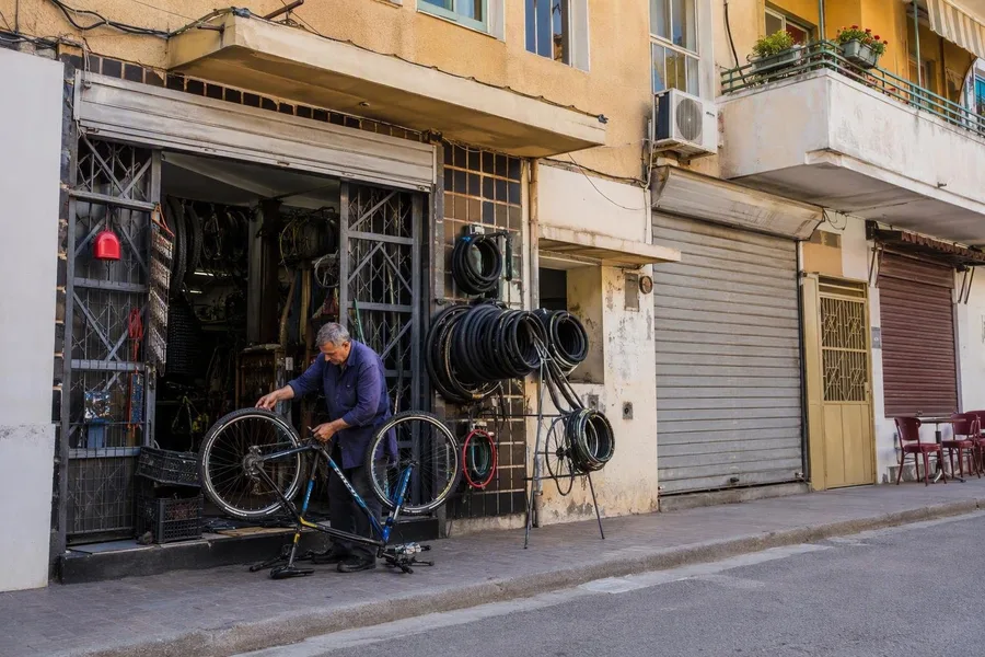 Een fietsenreparatiezaak werkt onder woningen aan Rruga Qemal Stafa, ten noorden van Pazari i Ri.