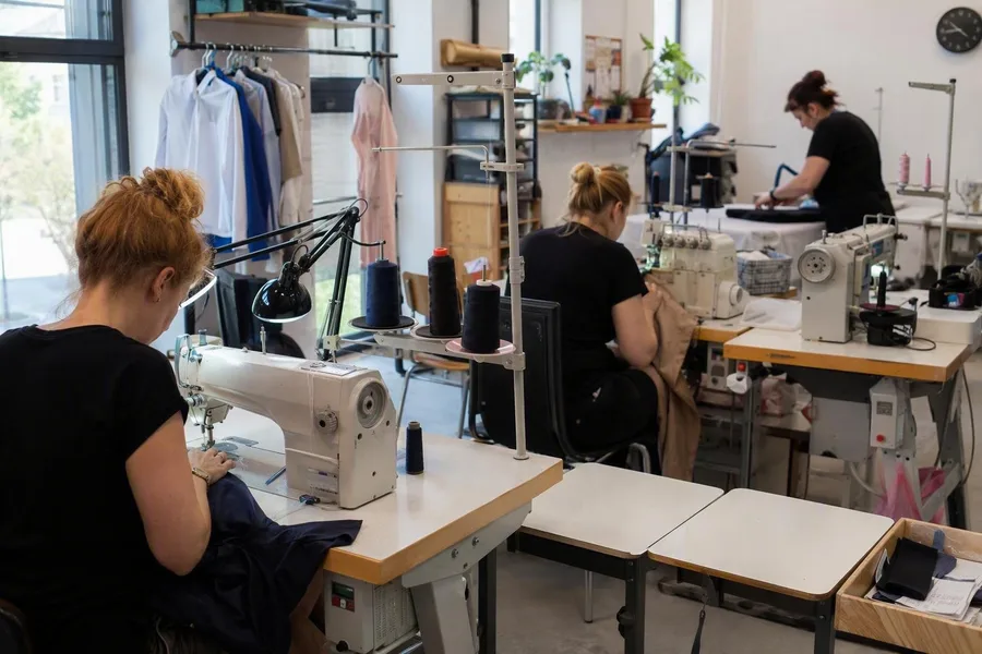 Kleermakers vermaken kleding bij ELES Zakład Krawiecki in Łódź.