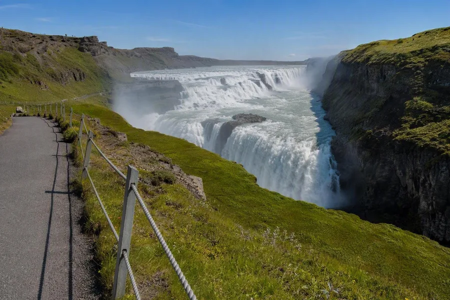 De bovenroute bij Gullfoss kijkt uit over de twee sprongen en nauwe kloof van de Hvítá.