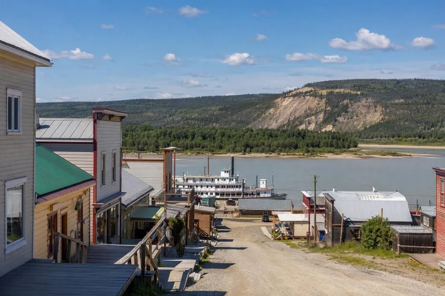 Houten panden en boardwalks aan Front Street lopen in Dawson City naar de Yukon.