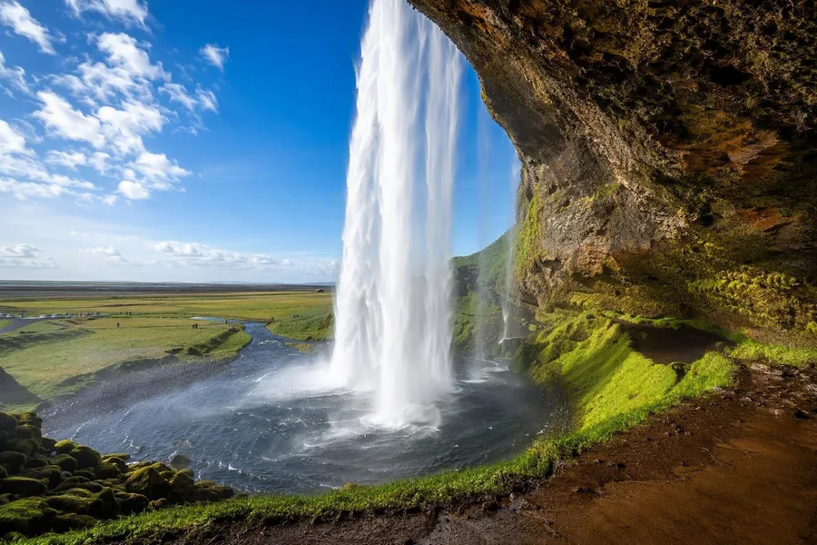 Seljalandsfoss gezien vanaf het natte pad achter het vallende watergordijn in IJsland.