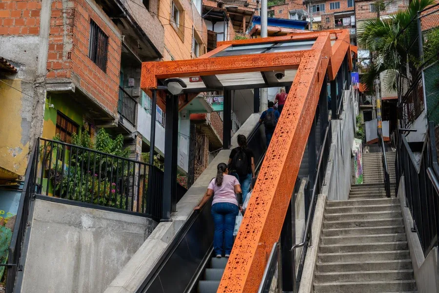 Bewoners gebruiken een overdekte openbare roltrap naast vaste trappen in Las Independencias I, Medellín.