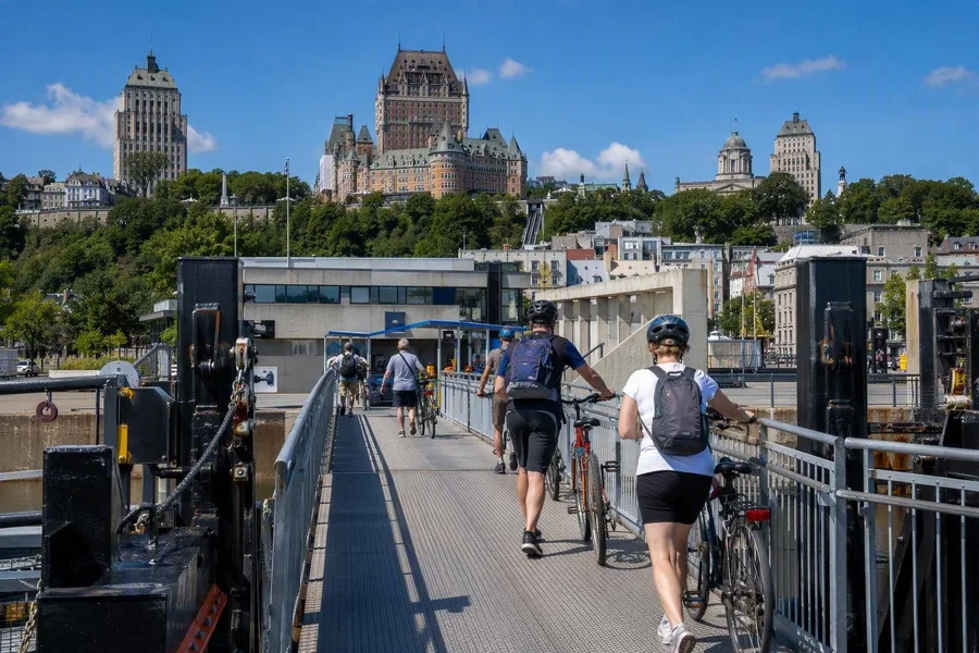Voetgangers en fietsers gaan aan boord bij de veerterminal onder de oude stad van Québec.
