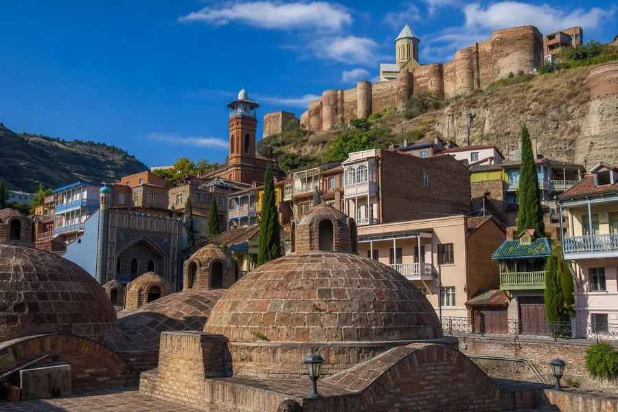 Gemetselde koepels van zwavelbaden rijzen op tussen oude huizen in Abanotubani in Tbilisi.