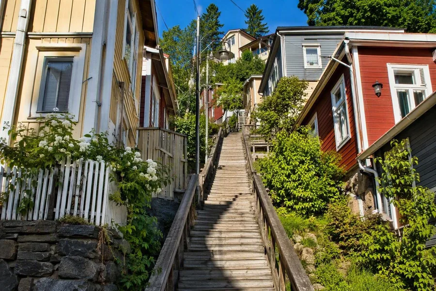 Houten huizen en een trap klimmen tegen de steile helling van Pispala in Tampere op.