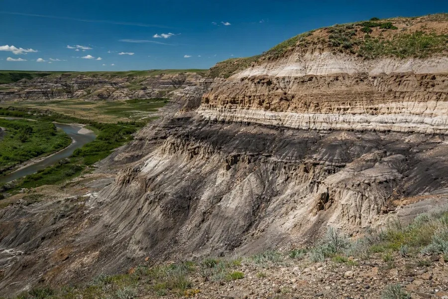 Eroded badlands ridges expose pale sandstone and dark shale in the Red Deer River valley near Drumheller.