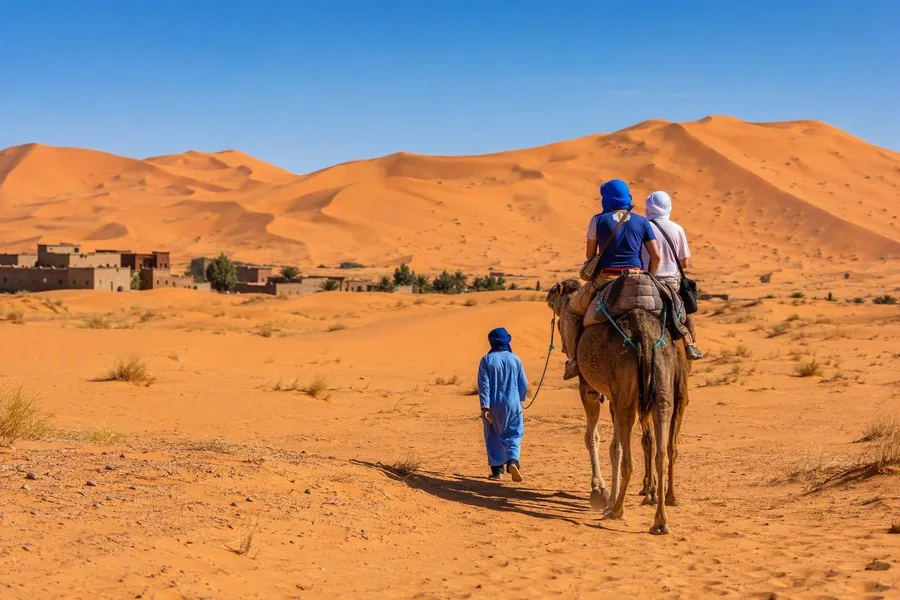 Een kameel brengt bezoekers vanuit Merzouga de Saharaduinen van Erg Chebbi in.