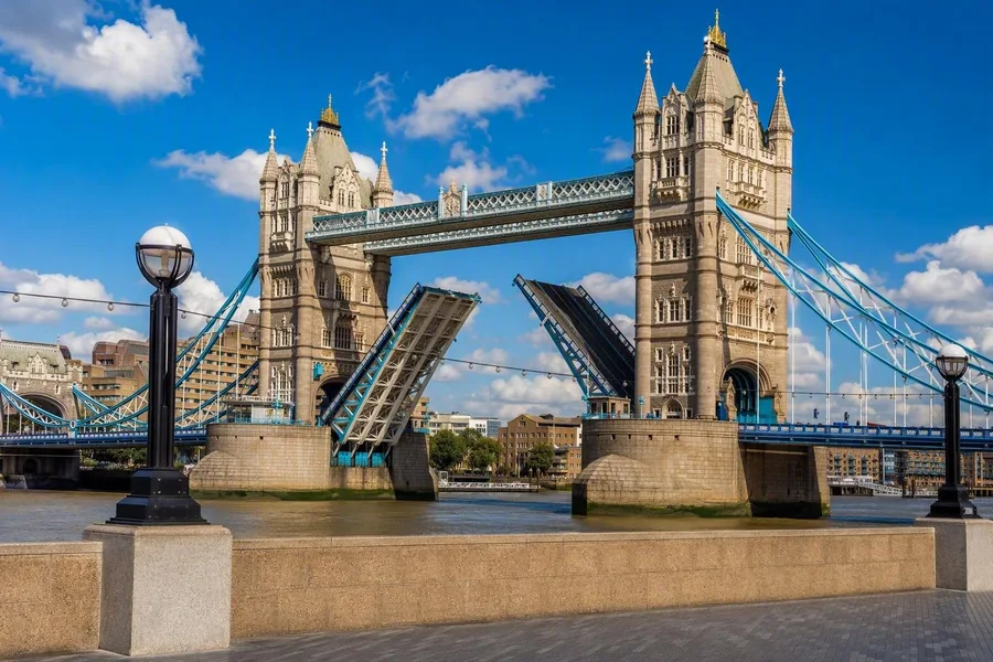 De met steen beklede torens van Tower Bridge omlijsten de geheven bascules boven de Theems in Londen.