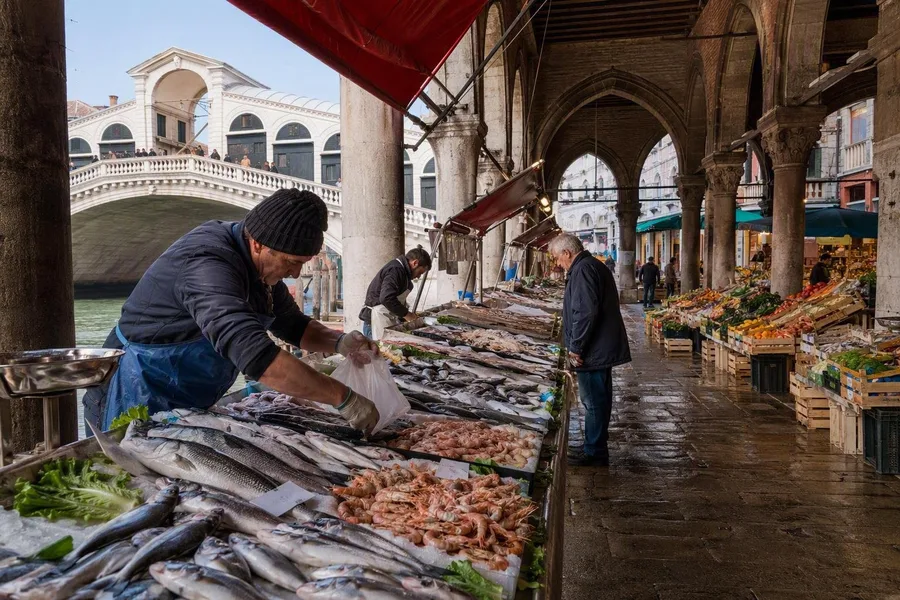 Visverkopers verkopen de ochtendvangst onder de vismarkt van Rialto in Venetië.