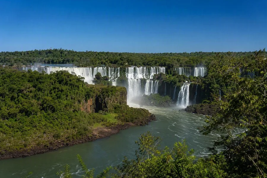 Meerdere cataracten van Iguazú overspannen de rivier, gezien vanaf het panoramapad in Brazilië.