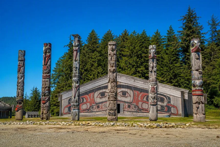 Zes monumentale palen staan voor het Haida Heritage Centre bij Ḵay Llnagaay nabij Skidegate.