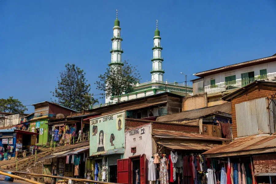 Groen-witte minaretten van de Green Mosque rijzen boven winkels en kleermakers in Biryogo uit.