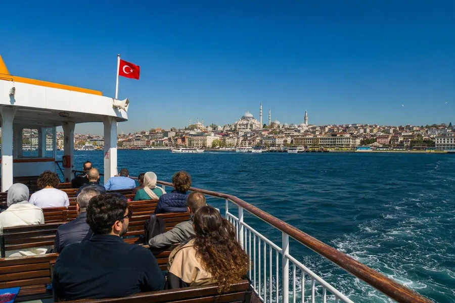 Passagiers varen vanaf Eminönü terwijl de historische landtong van Istanboel achter de ferry verdwijnt.