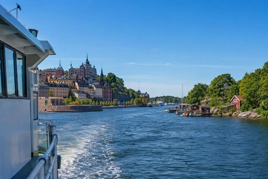 Een openbare veerboot uit Stockholm nadert beboste archipeloevers bij Vaxholm.