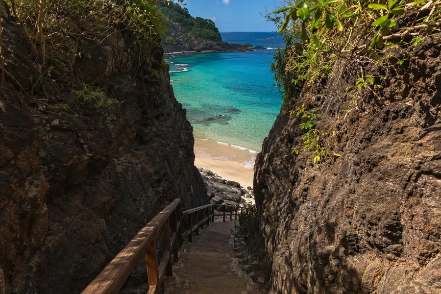 Een trap daalt door een rotsspleet af naar Praia do Sancho op Fernando de Noronha.