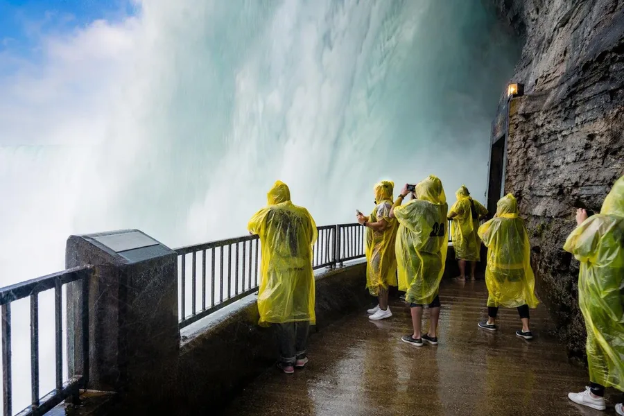 Bezoekers staan op het lage dek naast Horseshoe Falls bij Journey Behind the Falls.