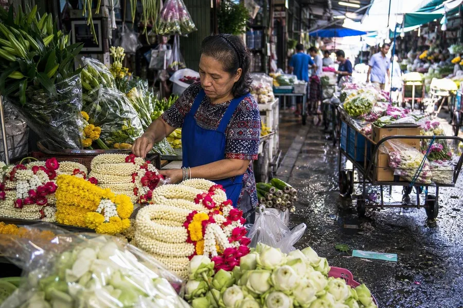 A seller arranges flowers and garlands at Bangkok’s Pak Khlong Talat in the morning.